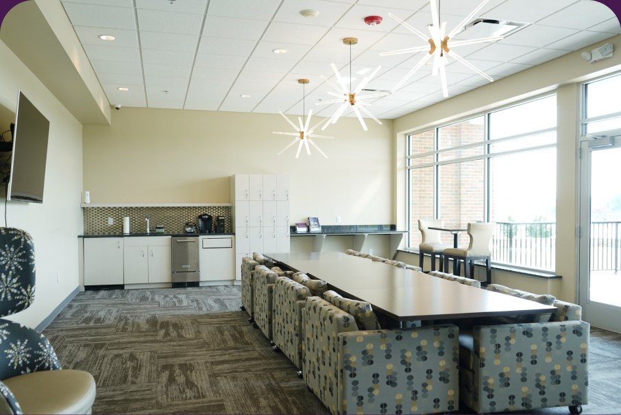 The VIP room: a long table under starburst pendant lights, with patterned chairs and a kitchenette behind.