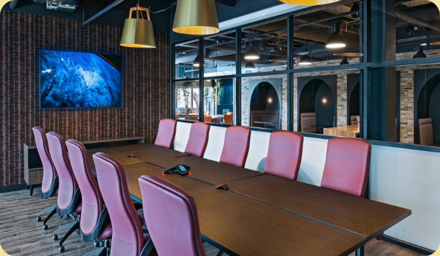 Saginaw coworking space: a boardroom with gold pendant lamps and CoWorkRC branding.